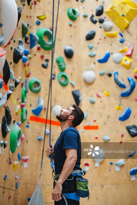 男子在室内攀岩馆进行保护图片素材
