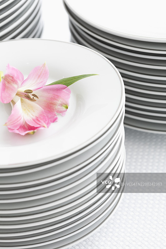 优雅的餐桌布置，叠放的盘子和精致的花卉装饰，适合特别活动图片素材