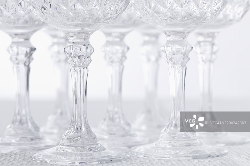优雅的水晶酒杯在浅色背景上以装饰性方式排列图片素材