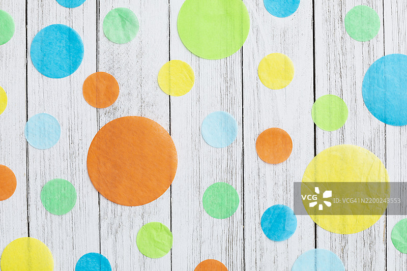 可定制的背景，上面有五彩纸圈，放在木质表面上，适合节庆场合使用图片素材