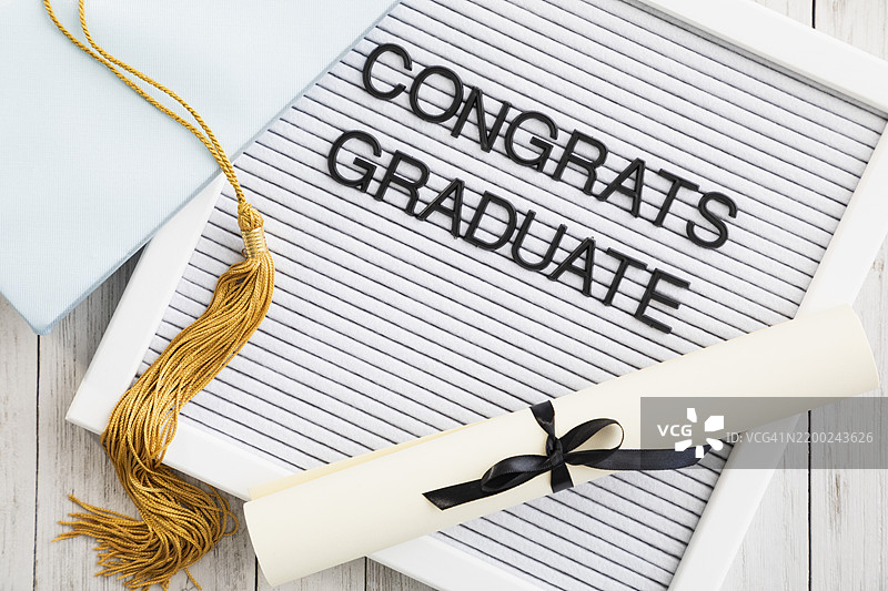 在温馨的环境中庆祝毕业，展示着文凭、学位帽和祝贺信息图片素材