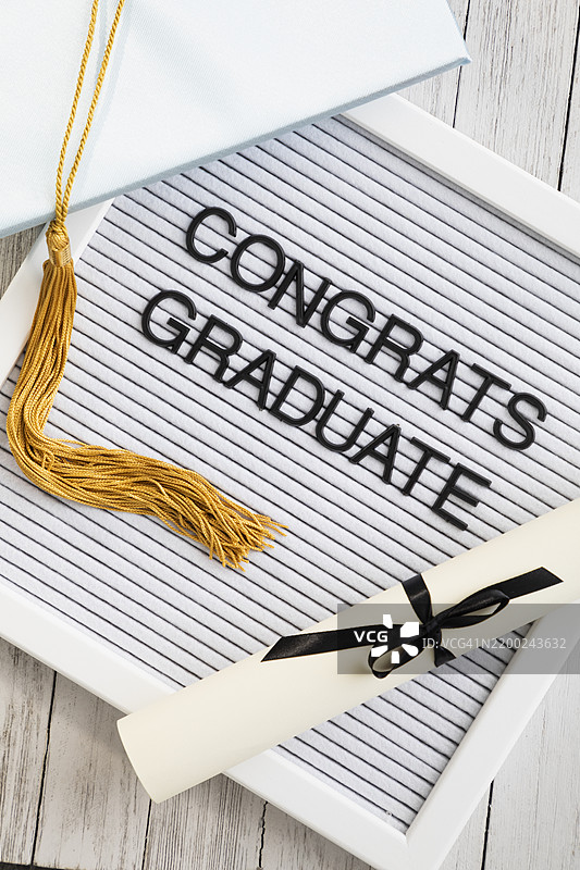 毕业庆祝活动，背景为木质，配有文凭、学位帽和祝贺信息图片素材