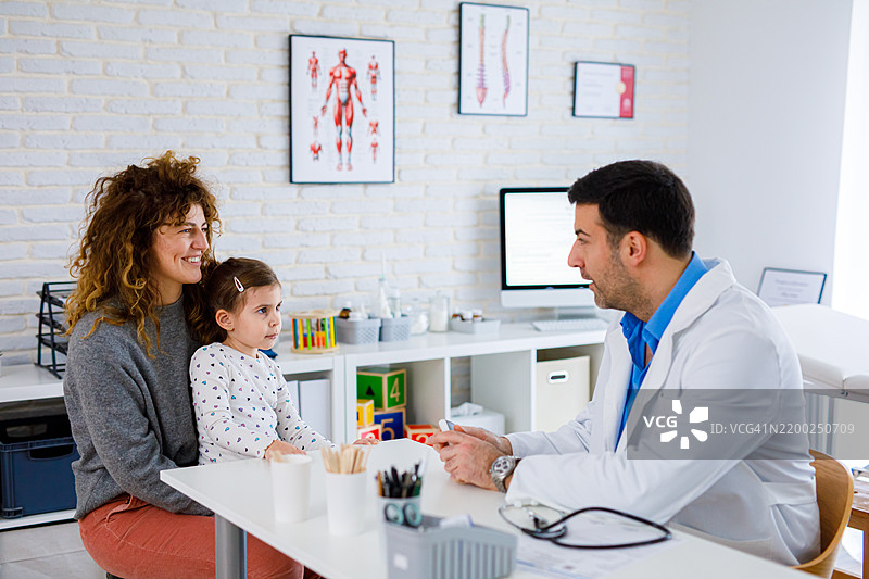 小女孩和她的母亲一起去儿科医生办公室。图片素材