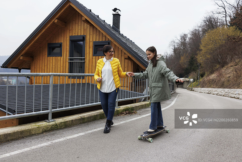 家庭乐趣：一起在户外滑板图片素材