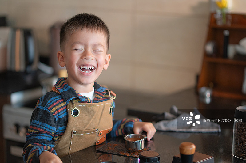 快乐的孩子在温馨的厨房环境中玩耍，像家庭咖啡师一样制作咖啡图片素材
