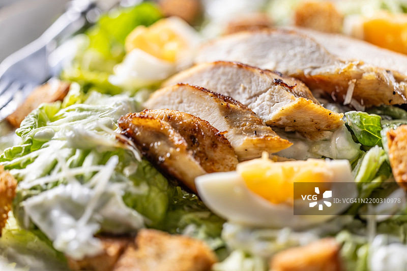 健康的凯撒沙拉，配有罗马生菜、烤鸡胸肉、鸡蛋、面包丁、酸奶酱和帕尔马干酪。图片素材