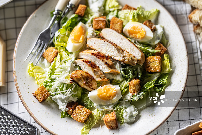健康的凯撒沙拉，配有罗马生菜、烤鸡胸肉、鸡蛋、面包丁、酸奶酱和帕尔马干酪。图片素材