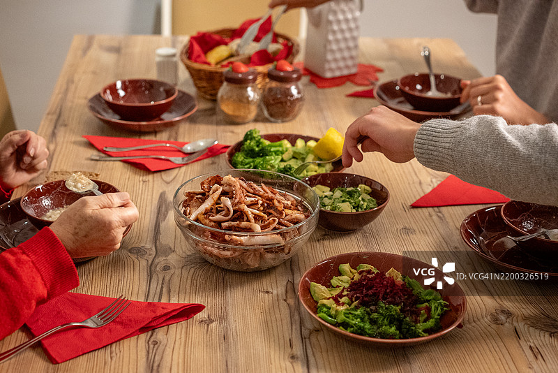 地中海家庭在餐桌旁。图片素材