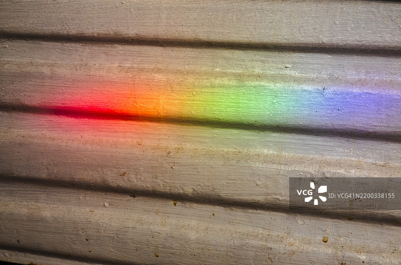 色彩斑斓的光谱在纹理表面上舞动图片素材