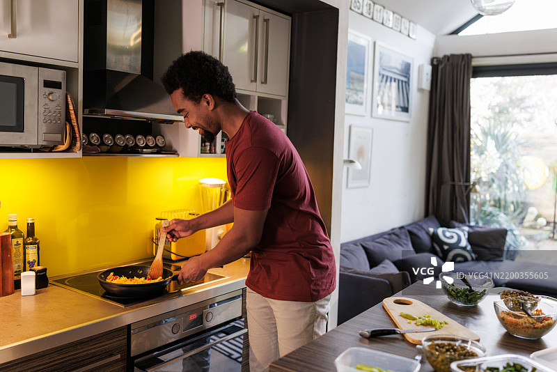 男人在温馨的厨房环境中准备家常菜图片素材