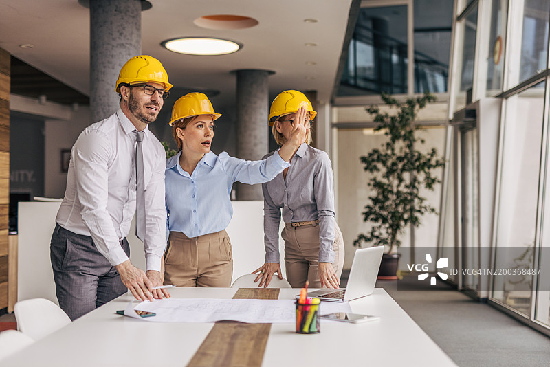建筑师们在一个项目上工作并指着某个东西图片素材