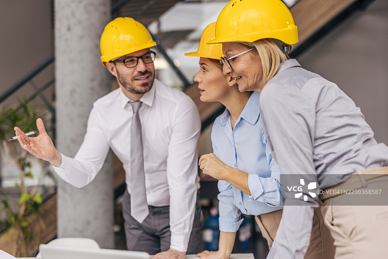 工程师们戴着安全帽在办公室开会图片素材