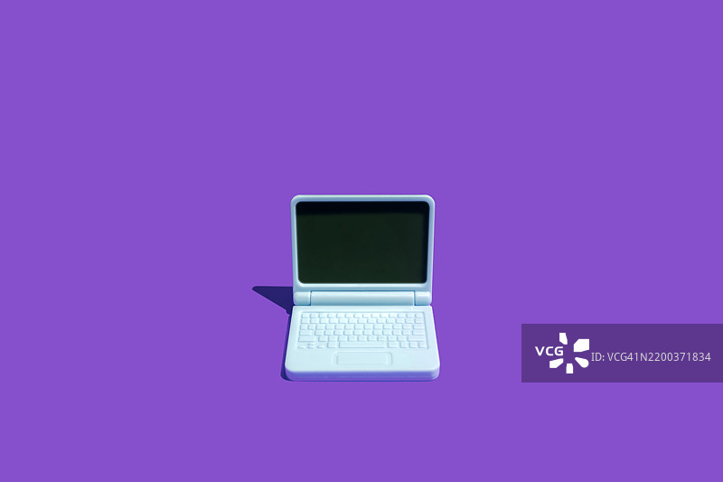 简约的青绿色笔记本电脑置于生动的紫色背景上，展示现代科技。图片素材