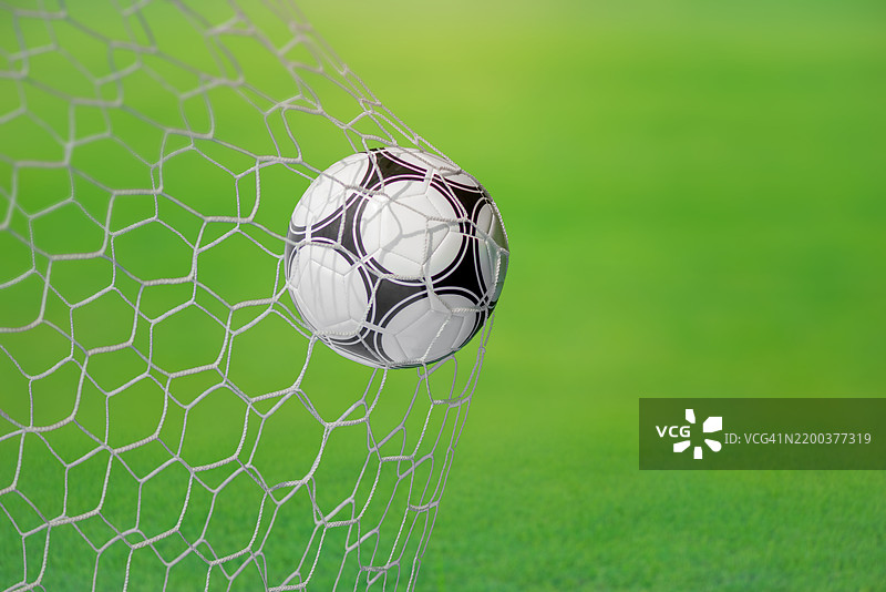 将足球踢进足球门网。大体育场内足球门的表面。图片素材