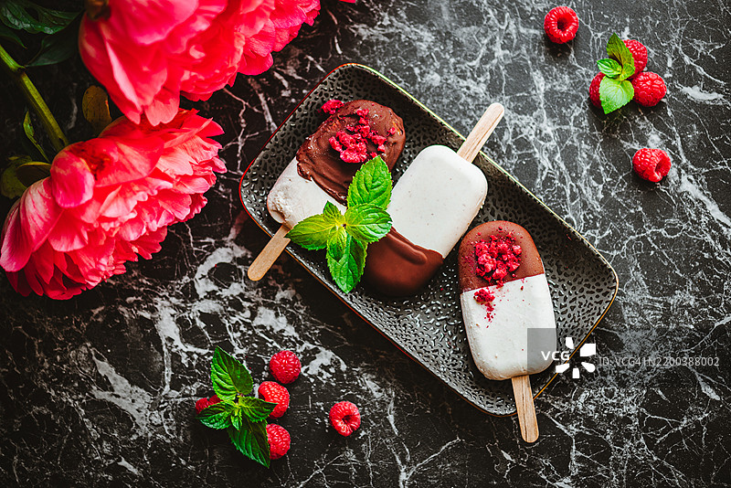 美味的自制香草冰淇淋冰棒，配有覆盆子和巧克力图片素材