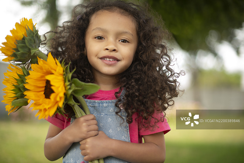 女孩、孩子与公园里的向日葵肖像，适合植物学习、儿童发展和感官体验。人物、信心与微笑在户外采花、探索自然和春天。图片素材