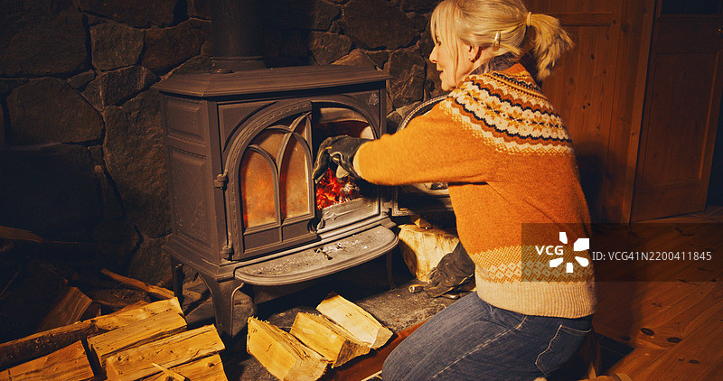 女人在加燃料到炉子里图片素材