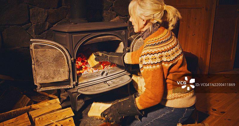 女人在加燃料到炉子里图片素材