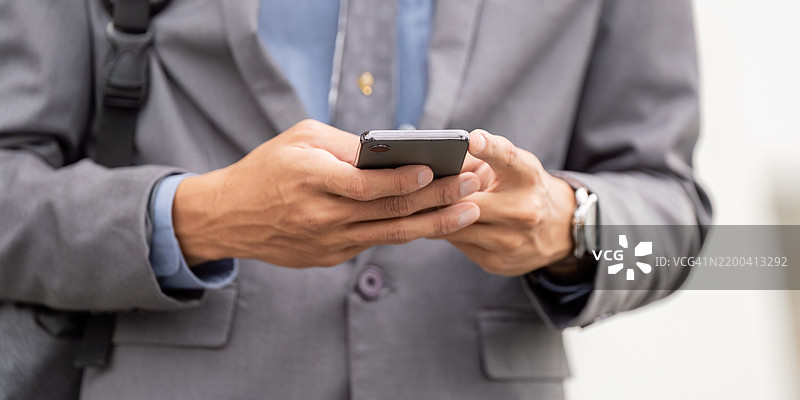 年轻亚洲商人近距离使用智能手机发送信息图片素材