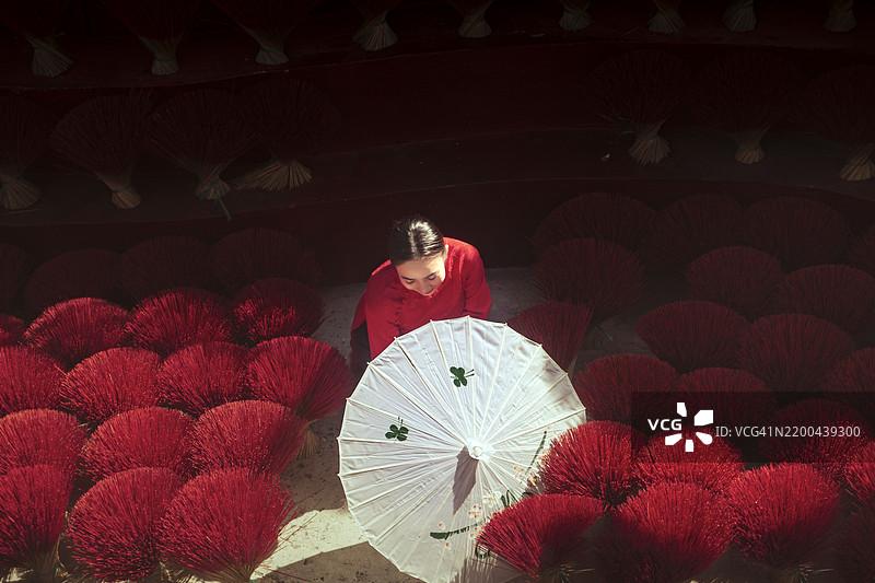 手持雨伞的男人站在红色墙壁前图片素材