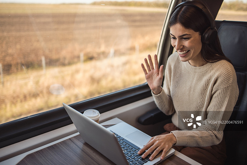 在火车旅行中通过视频通话和笔记本电脑保持高效的女性图片素材