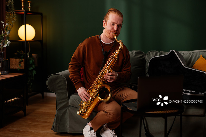 音乐家在家中进行在线课程时演奏萨克斯ophone图片素材