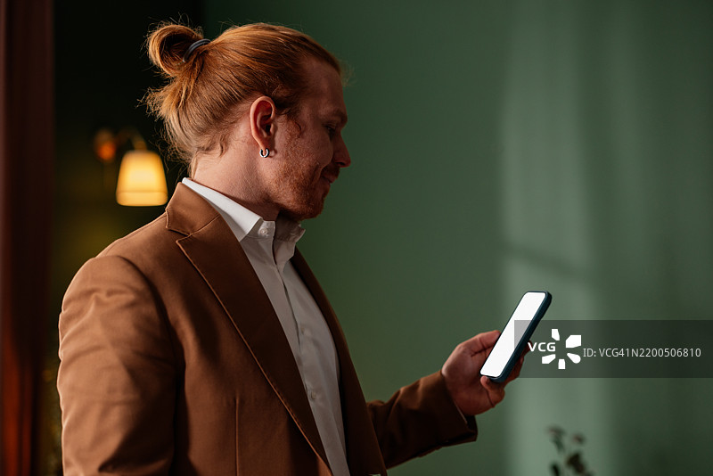 商人在现代办公室使用带有空白屏幕的智能手机图片素材