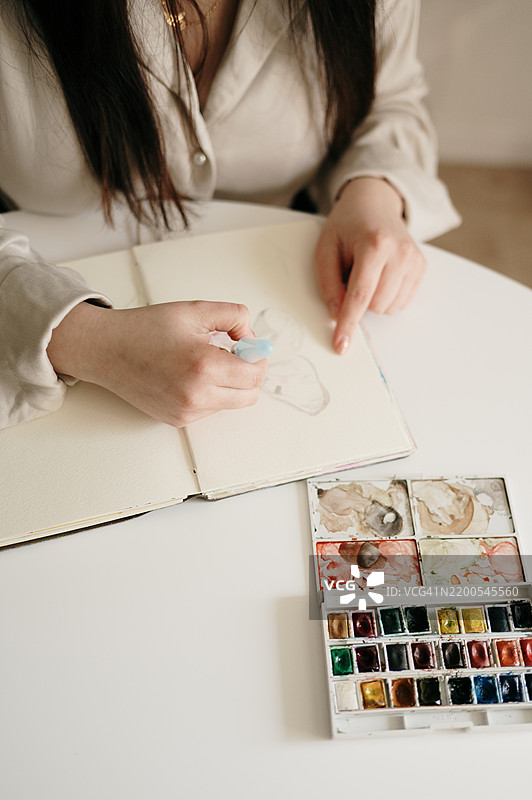一位女性用水彩画作的细节图片素材