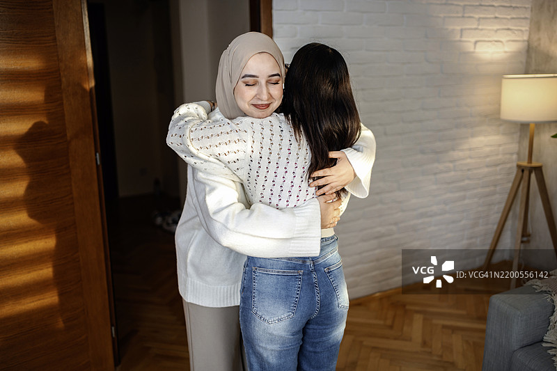 两个多种族的朋友在家里互相拥抱图片素材