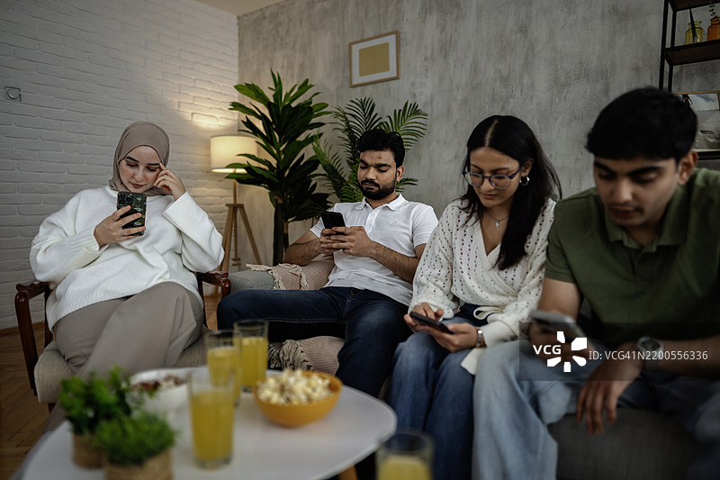 年轻人在家沙发上使用智能手机图片素材