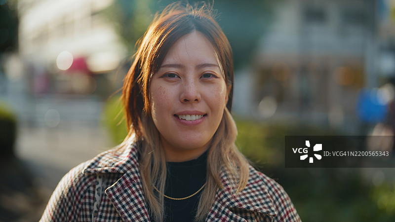 城市光影中微笑女性的肖像图片素材