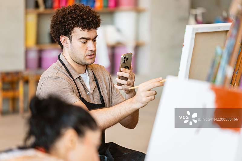 中东艺术家在工作室拍摄绘画过程图片素材