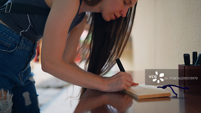 女性游客在日本神社参拜，并在木制祈愿牌上写下她的愿望图片素材