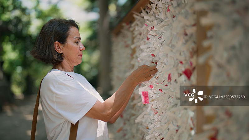 女性游客参观神社并系上御御签（签文纸）图片素材