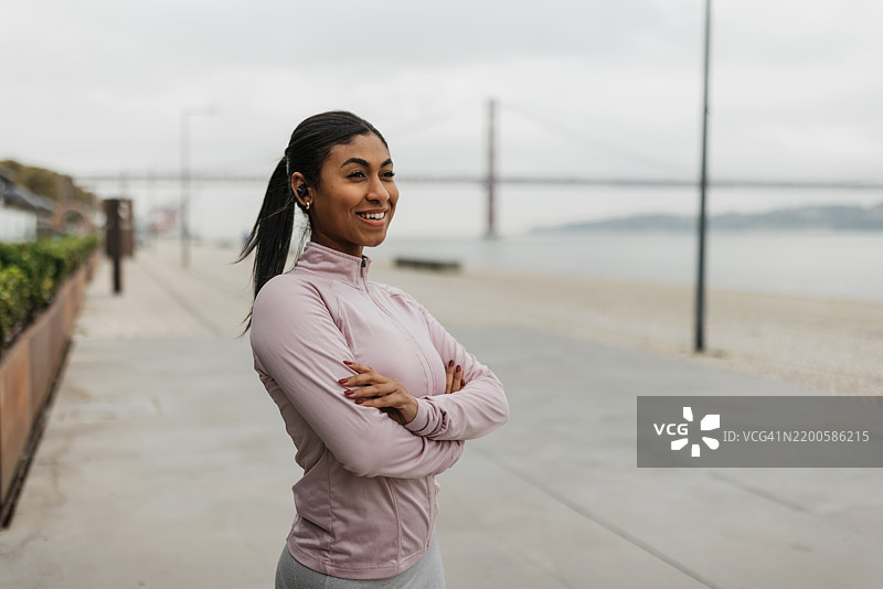 微笑的女性自信地在水边摆姿势图片素材
