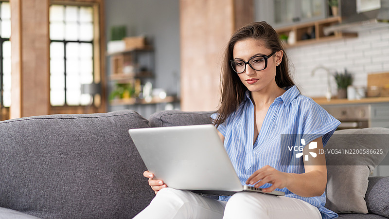 女性使用电脑电子银行应用程序计算家庭开支、支付账单或税款，规划投资或查看财务数据。生活在经济通货膨胀中。图片素材