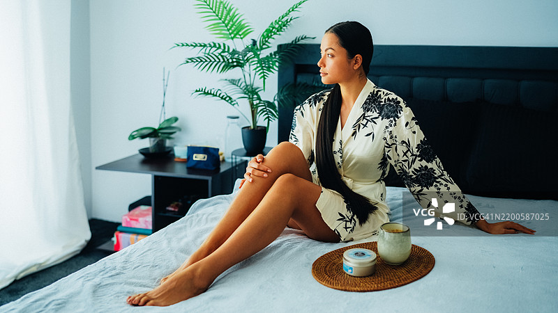 在家中使用乳木果身体乳的女性图片素材