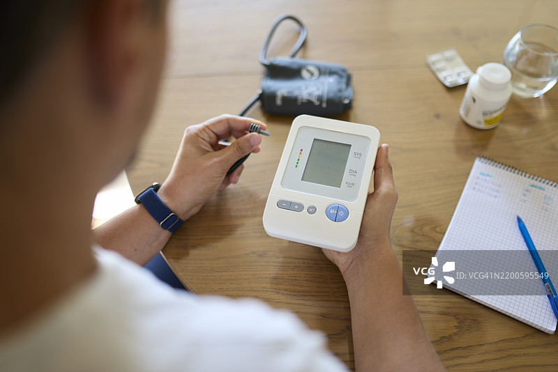 男子准备血压监测仪进行日常测量图片素材