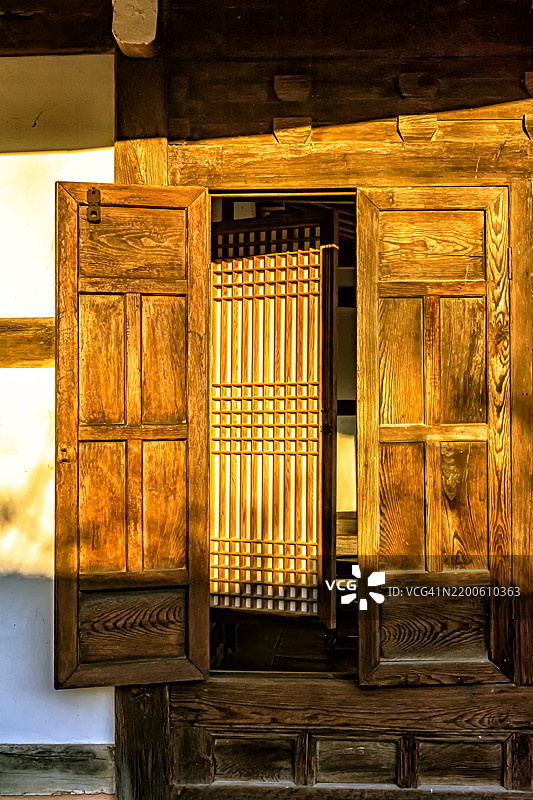 温暖的阳光洒在传统木门上图片素材