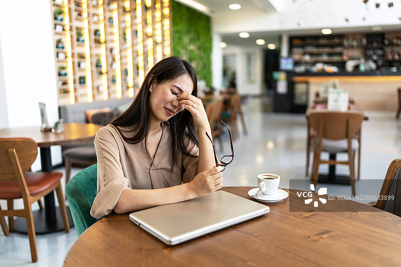 疲惫的女商人用双手捂住脸。图片素材