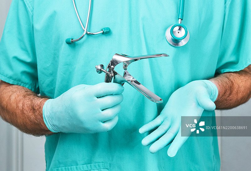 妇科医生手持阴道窥器。图片素材