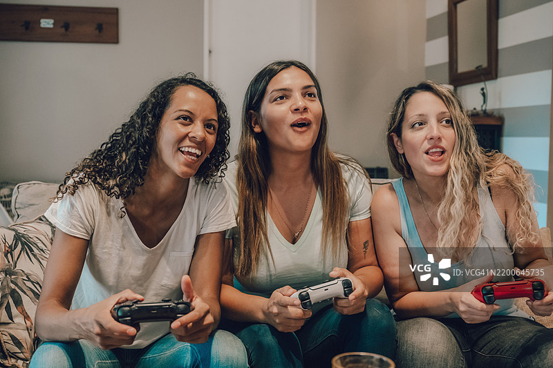 三位年轻女性一起玩视频游戏的肖像图片素材