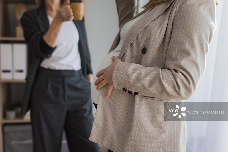 孕妇商务女性触摸腹部的特写镜头图片素材
