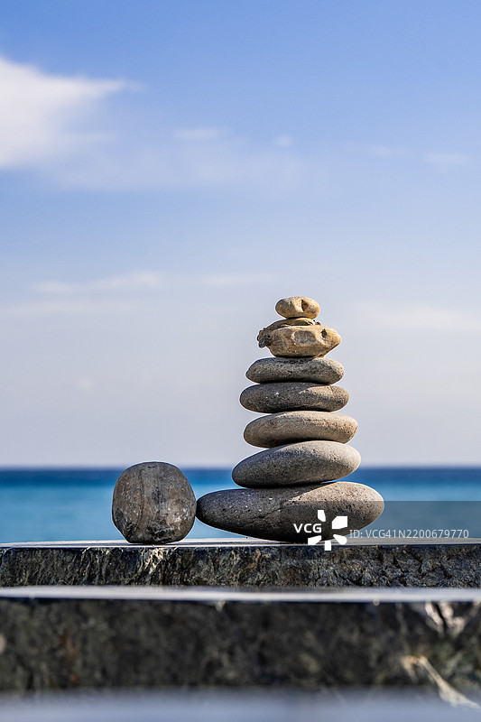 海滩上堆叠的卵石特写，背景是天空图片素材