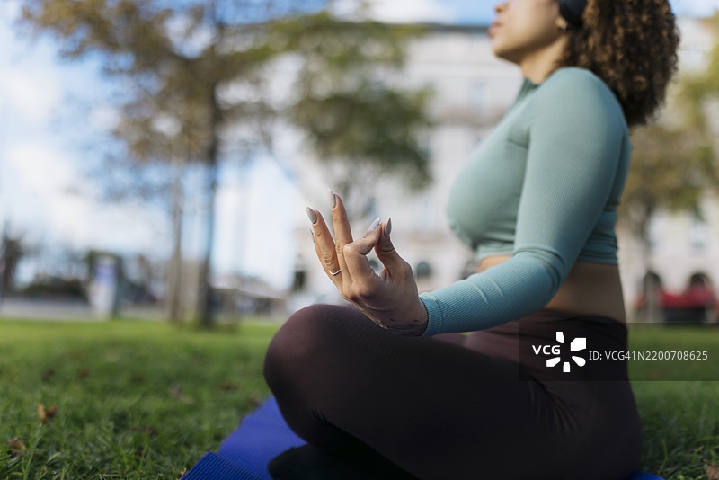 年轻女性在城市公园练习瑜伽和冥想图片素材