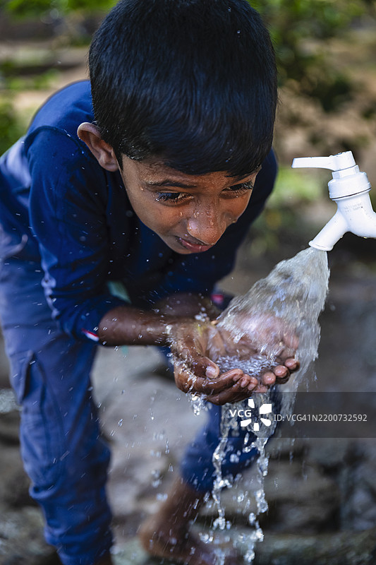 斯里兰卡小男孩在喝水，锡兰图片素材