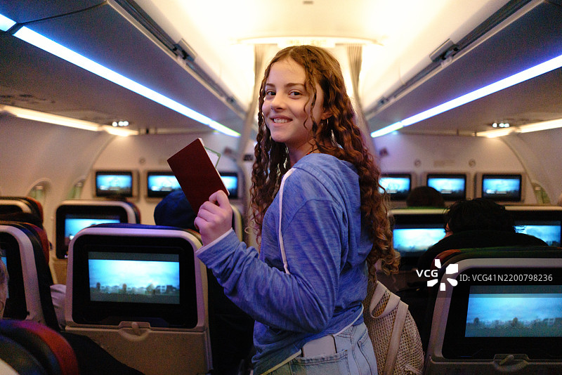 女孩手持护照走进飞机。图片素材