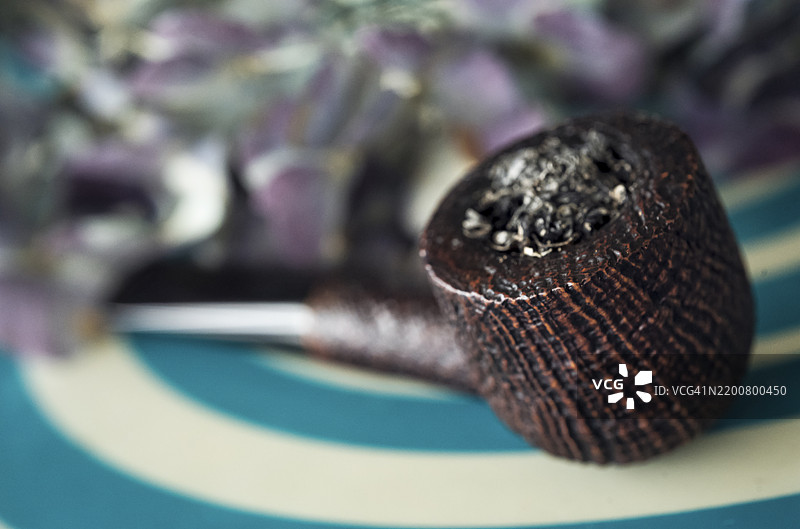 美妙的喷砂陶土烟斗放在金属桌子上图片素材