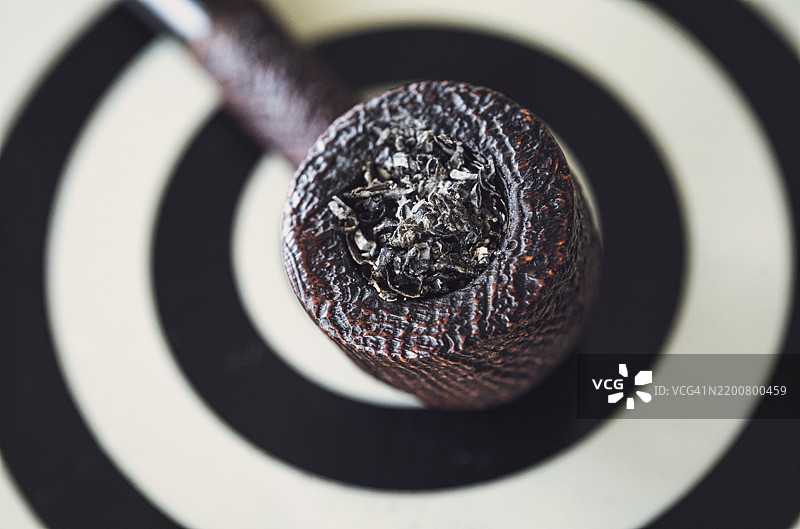 美妙的喷砂陶土烟斗放在金属桌子上图片素材