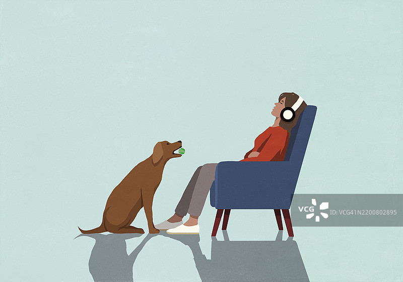 坐在扶手椅上的无知女性面前，狗狗正拿着球。图片素材